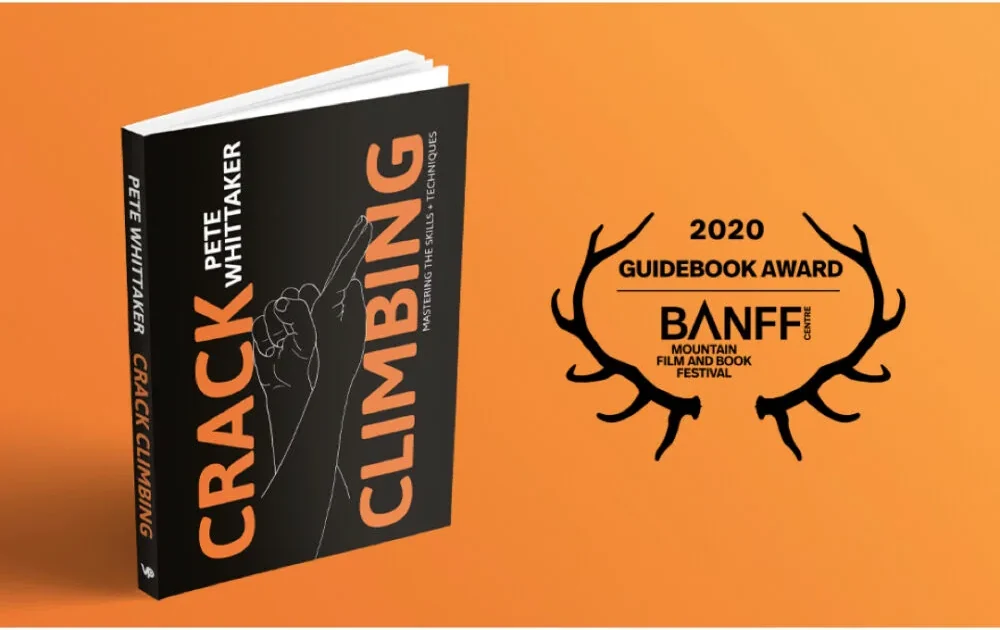 The Crack Climbing book beside the Banff Mountain Book Festival 2020 Guidebook Award laurel, on the cover's orange