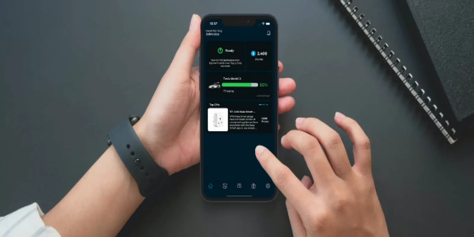 Hands holding a phone running the equiwatt app over a desk